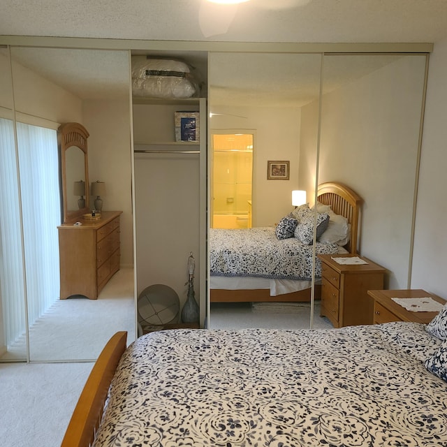 bedroom with ceiling fan, light carpet, and a closet