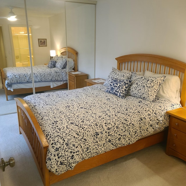 bedroom with light colored carpet and a closet