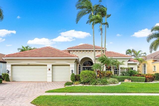 mediterranean / spanish-style house with a garage and a front lawn