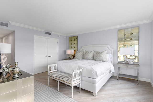 bedroom featuring a closet, light hardwood / wood-style flooring, and ornamental molding