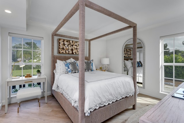 bedroom with crown molding, multiple windows, and light hardwood / wood-style flooring