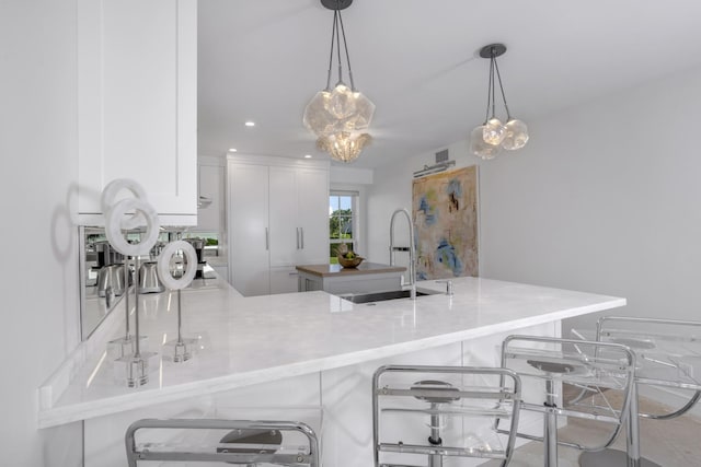 kitchen featuring sink, a breakfast bar, pendant lighting, and kitchen peninsula