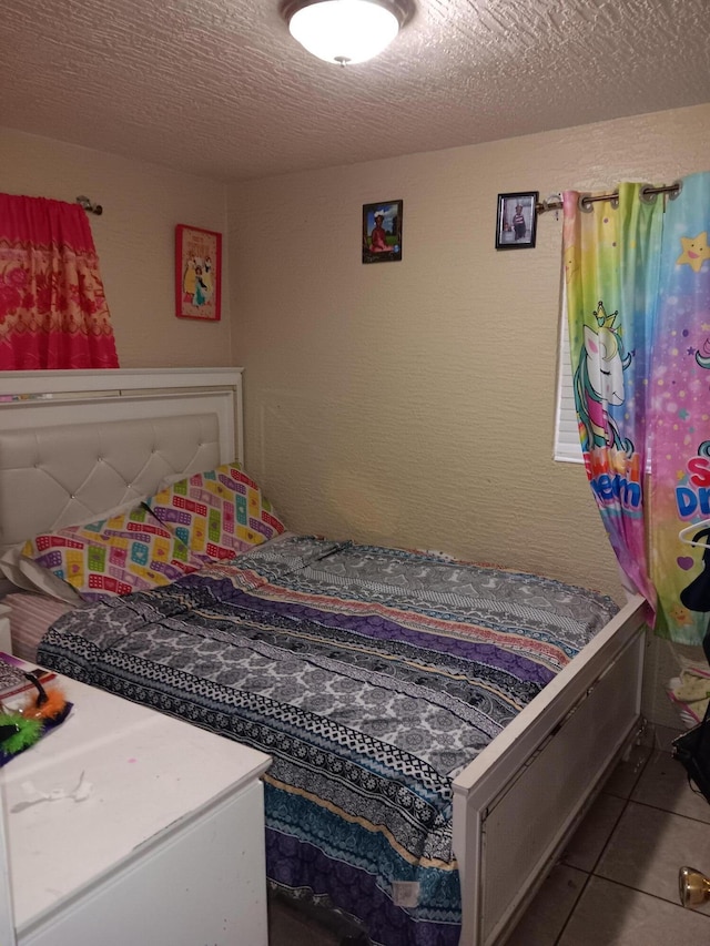 bedroom featuring a textured ceiling and light tile patterned flooring