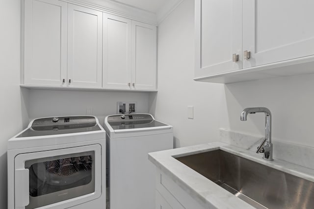 washroom featuring cabinets, sink, and washer and dryer