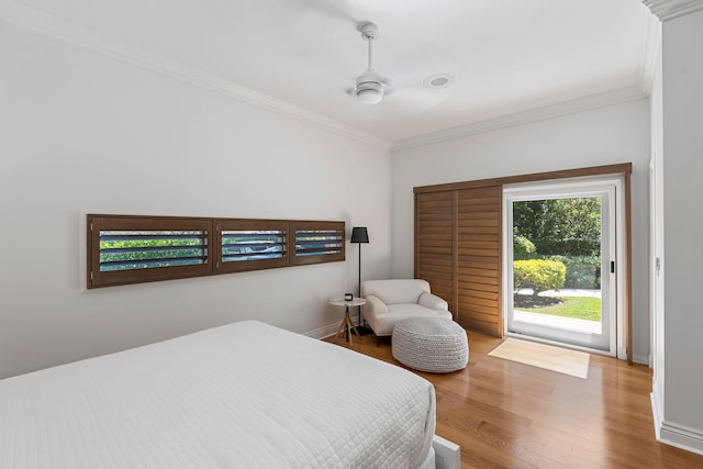 bedroom featuring access to exterior, hardwood / wood-style flooring, ceiling fan, and crown molding