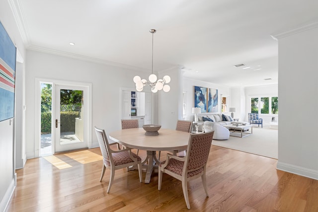 dining space featuring crown molding, a healthy amount of sunlight, and light wood-type flooring