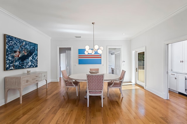 dining space featuring a notable chandelier, crown molding, and light hardwood / wood-style flooring