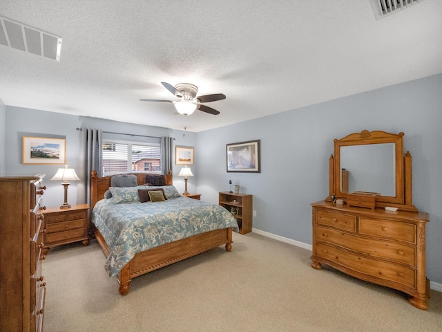 carpeted bedroom featuring ceiling fan and a textured ceiling