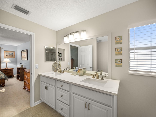 bathroom with a textured ceiling and vanity