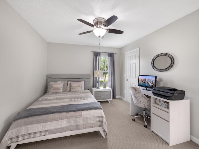 bedroom with ceiling fan, a textured ceiling, and light carpet