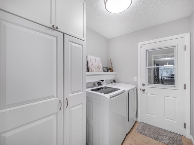 laundry room featuring a textured ceiling, cabinets, and separate washer and dryer