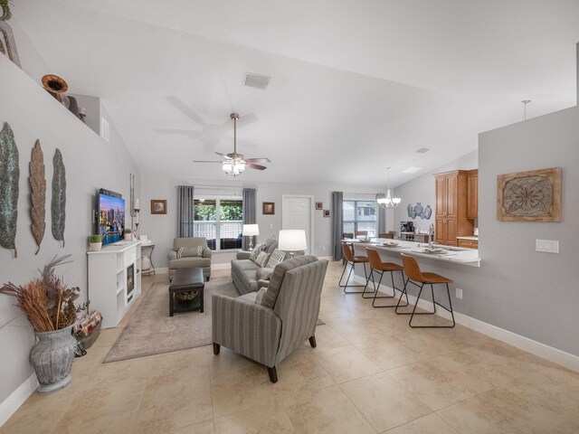 living room with vaulted ceiling and ceiling fan with notable chandelier