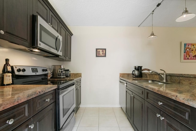 kitchen with pendant lighting, sink, a textured ceiling, appliances with stainless steel finishes, and light stone counters