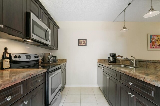 233 Charter Way, West Palm Beach, FL 33407 - kitchen with appliances with stainless steel finishes, a sink, stone countertops, decorative light fixtures, and light tile patterned flooring