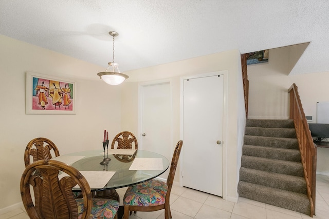 tiled dining room with a textured ceiling