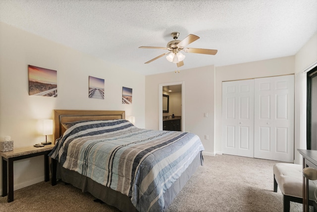 carpeted bedroom featuring connected bathroom, ceiling fan, a closet, and a textured ceiling