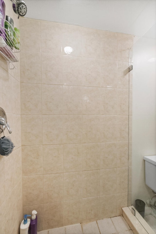 bathroom with toilet and a tile shower