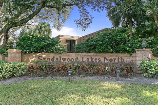 community / neighborhood sign featuring a lawn