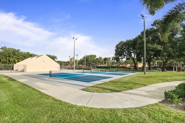 view of pool with a lawn and tennis court