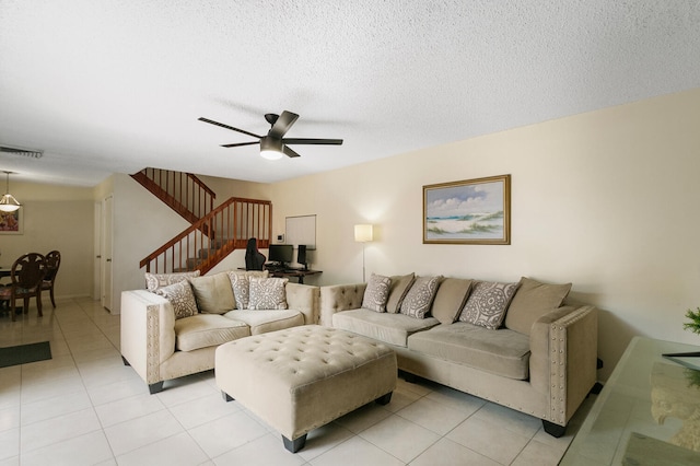 tiled living room with a textured ceiling and ceiling fan