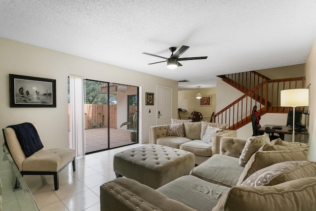 living room featuring light tile patterned floors, a textured ceiling, and ceiling fan