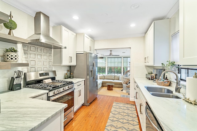 kitchen featuring white cabinets, appliances with stainless steel finishes, and wall chimney range hood