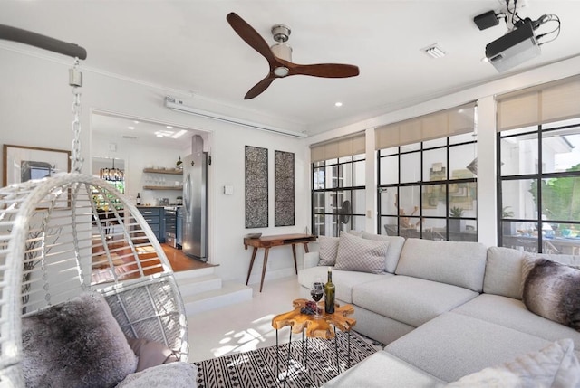 living room with ornamental molding and ceiling fan