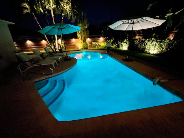 view of swimming pool with a patio and a water view