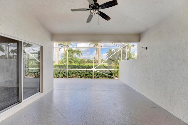 unfurnished sunroom with ceiling fan