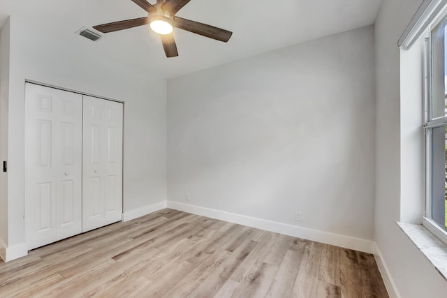 unfurnished bedroom with a closet, light hardwood / wood-style floors, and ceiling fan