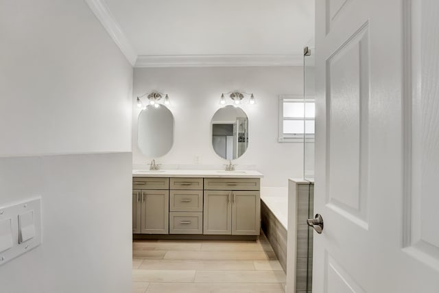 bathroom featuring ornamental molding, vanity, a tub to relax in, and wood-type flooring