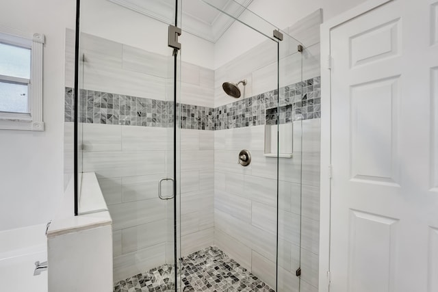 bathroom featuring ornamental molding and a shower with door