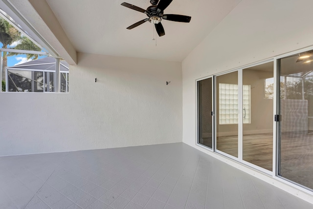 view of patio featuring glass enclosure and ceiling fan