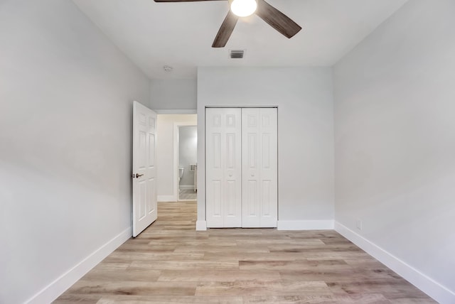 unfurnished bedroom with light hardwood / wood-style floors, ceiling fan, and a closet