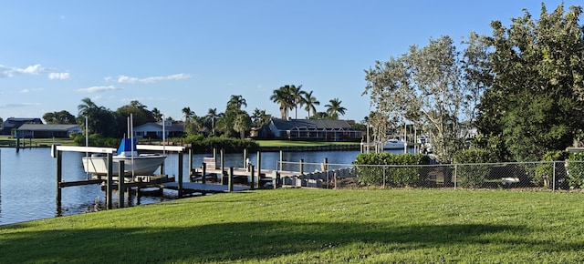 dock area with a water view and a yard