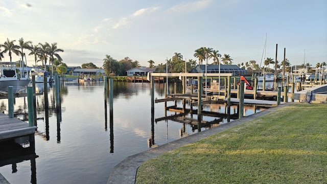 view of dock with a water view and a yard