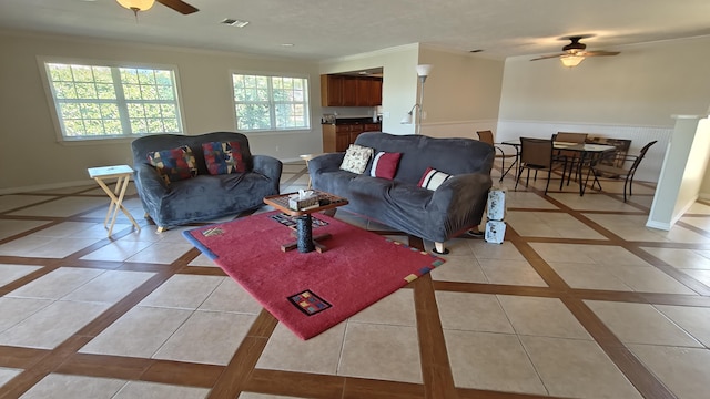 living room with ceiling fan, light tile patterned flooring, and crown molding