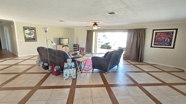 tiled living room featuring ceiling fan, a textured ceiling, and ornamental molding