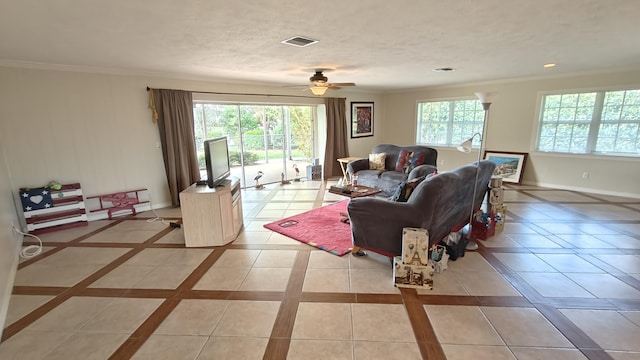 tiled living room with ceiling fan and crown molding