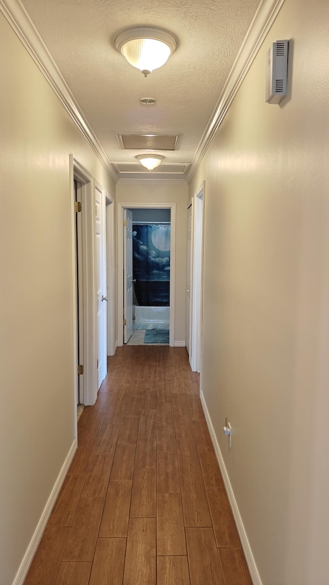 hallway with a textured ceiling and ornamental molding