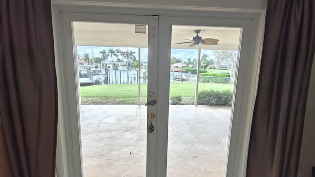 entryway with a wealth of natural light, a water view, and ceiling fan