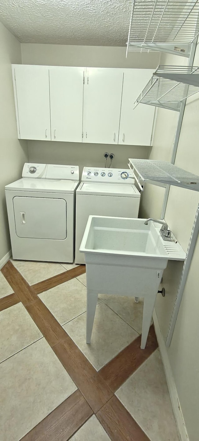 washroom featuring cabinets and washing machine and clothes dryer