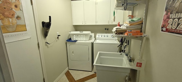 washroom featuring cabinets, light tile patterned floors, and washing machine and clothes dryer