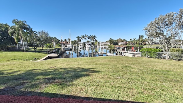 dock area with a water view and a lawn