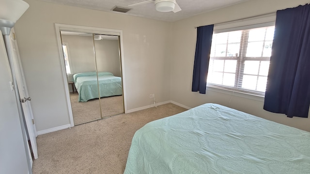 carpeted bedroom featuring ceiling fan and a closet