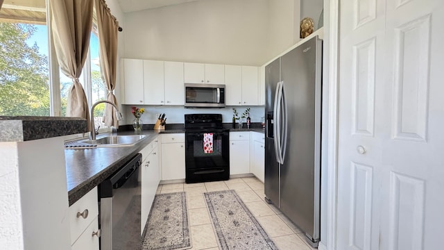 kitchen with white cabinetry, sink, light tile patterned floors, and appliances with stainless steel finishes