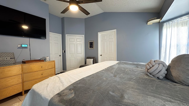 carpeted bedroom with a textured ceiling, ceiling fan, and vaulted ceiling