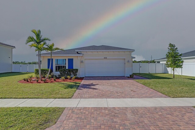 view of front of property featuring a lawn and a garage