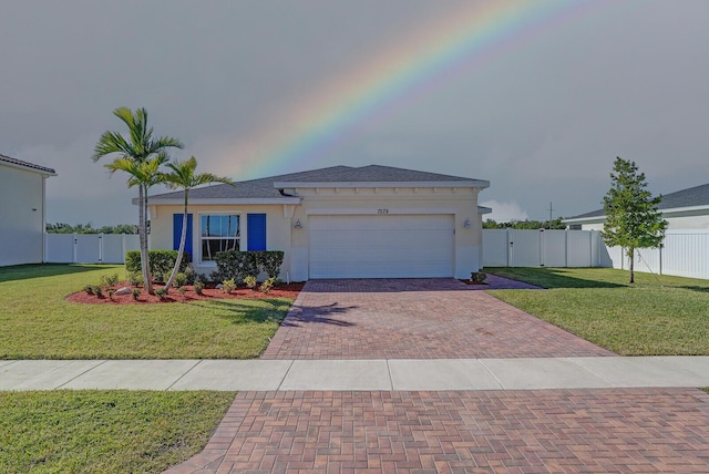 view of front of house featuring a garage, decorative driveway, a front yard, and fence