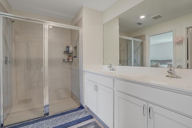 ensuite bathroom with double vanity, ensuite bath, a sink, and a shower stall